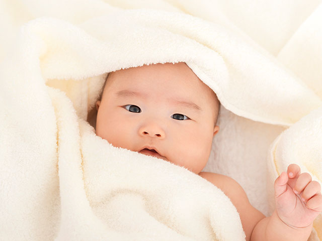 出産祝いに本当に喜ばれる贈り物はタオル。タオルに包まれる赤ちゃん