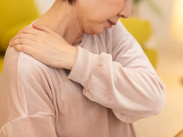 冬の夜のリビングで肩こりに苦しむミドル〜シニア女性