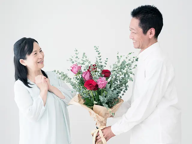 結婚記念日のプレゼントに花束をもらい感激する妻