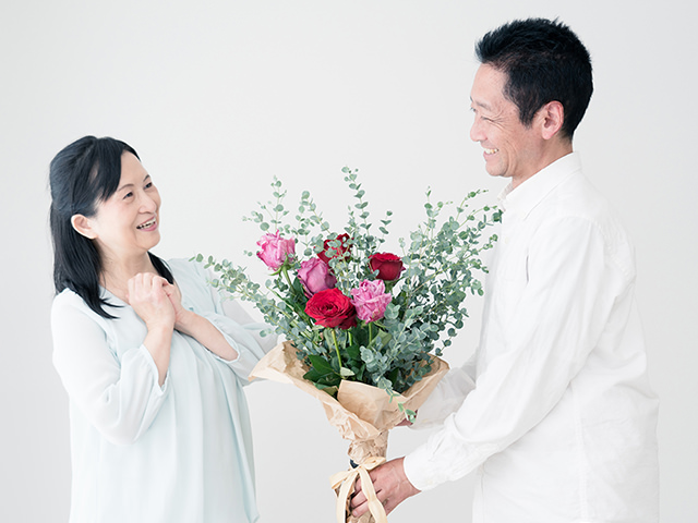 結婚記念日のプレゼントに花束をもらい感激する妻